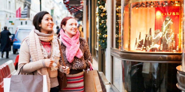 Women with shoopingbags looking at shopwindow.