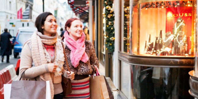 Women with shoopingbags looking at shopwindow.