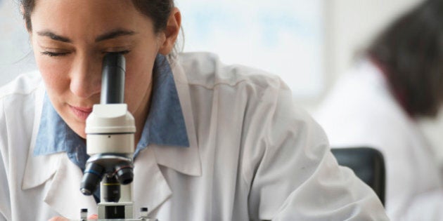 Mixed Race scientist using microscope