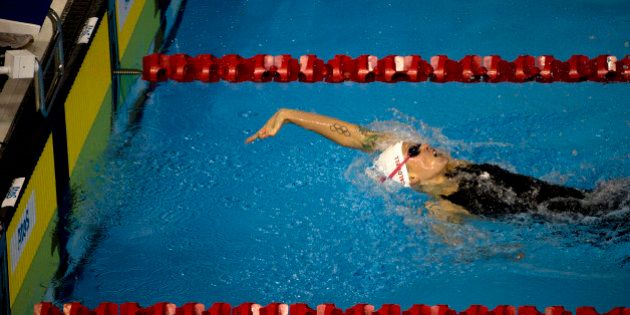 Hilary Caldwell of Canada reaches back for the wall as she finishes first in her heat and second overall in the women's 200m backstroke preliminaries, at the Pan Am games in Toronto, Wednesday, July 15, 2015. (AP Photo/Rebecca Blackwell)
