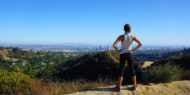 Beautiful Woman overlooking Los Angeles from a local hiking trail in Franklin Canyon, Beverly Hills, California