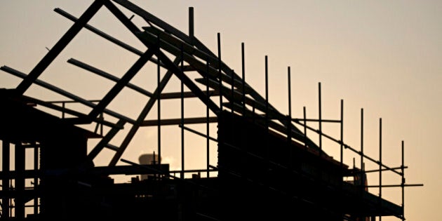 View of a silhouetted timber house in construction