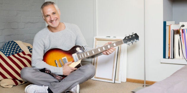 Portrait of a happy man playing a guitar