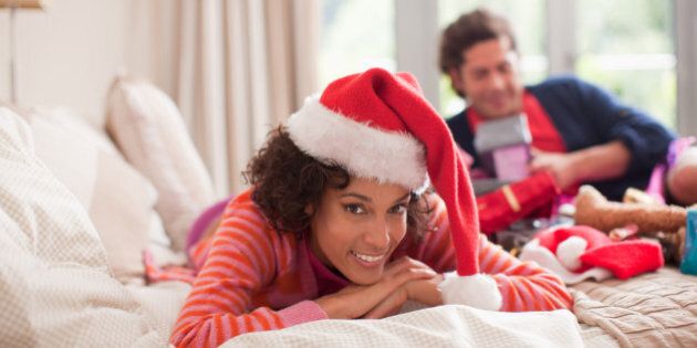 Couple opening gifts on bed