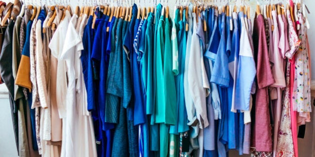 Colorful women's dresses on hangers in a retail shop. Fashion and shopping concept