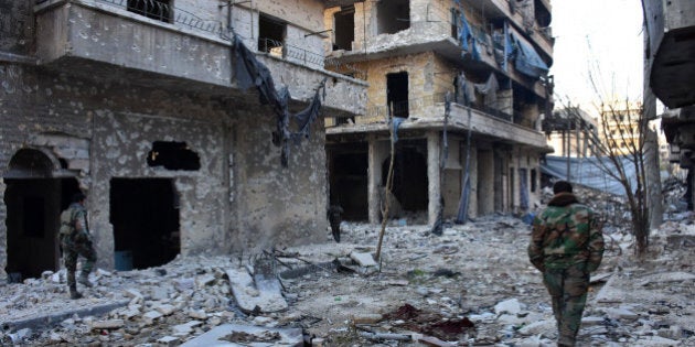 Syrian pro-government forces walk amidst heavy destruction in Aleppo's Bustan al-Basha neighbourhood on November 28, 2016, during their assault to retake the entire northern city from rebel fighters.In a major breakthrough in the push to retake the whole city, regime forces captured six rebel-held districts of eastern Aleppo over the weekend, including Masaken Hanano, the biggest of those in eastern Aleppo. / AFP / GEORGE OURFALIAN (Photo credit should read GEORGE OURFALIAN/AFP/Getty Images)