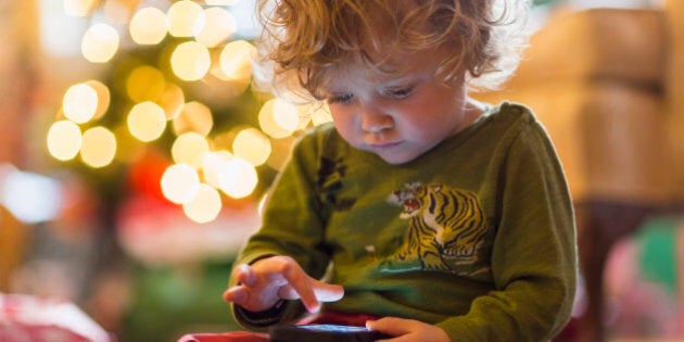 Caucasian baby boy playing with cell phone