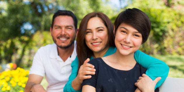 Portrait of happy family smiling together in a park