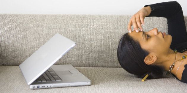 Woman with headache and laptop