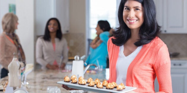 Happy woman with appetizers hosting home sales party