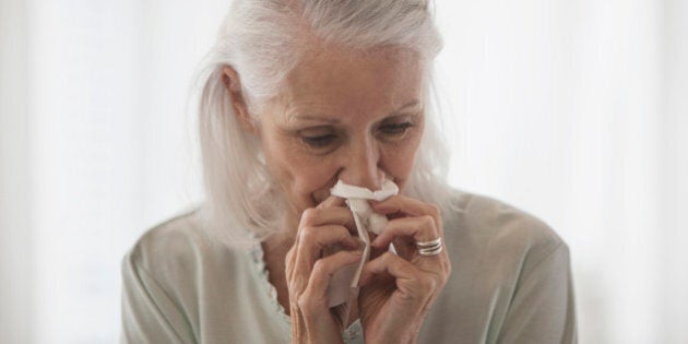 Senior Caucasian woman blowing her nose