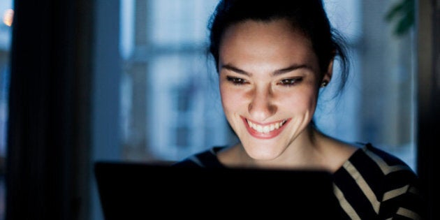 Woman lit by screen.