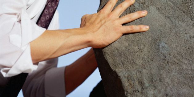 Businessman Pushing Against a Boulder