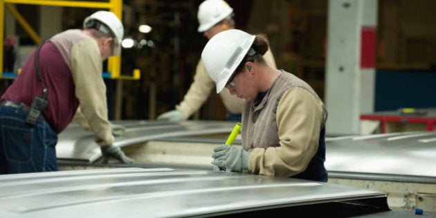 Before they are welded to assemble a mini-van body, workers inspect sheet metal components for flaws and distortions of shape.