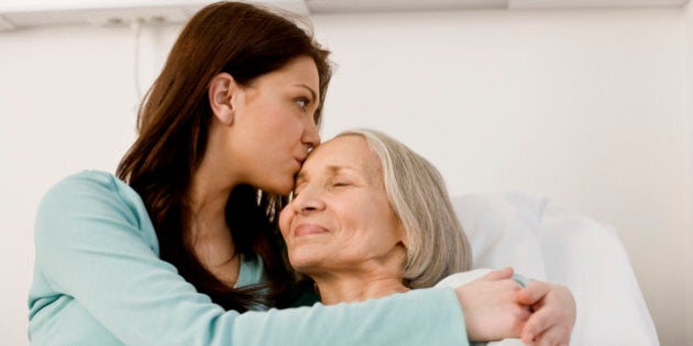 Woman kissing patient in bed