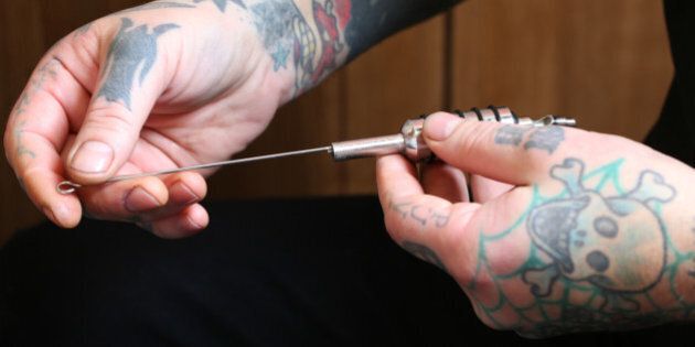 Tattoo artist, preparing tattoo ink gun.