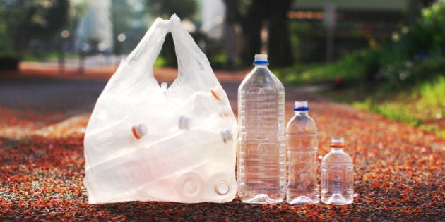 A bag of PET bottle and three loose PET bottles ready to be taken to recycle bin.