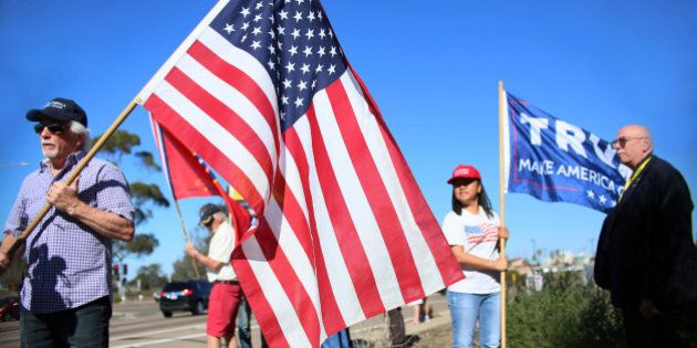 Demonstrators hold signs in support of President elect Donald Trump outside of Camp Pendleton in Oceanside, California, U.S. November 11, 2016. REUTERS/Sandy Huffaker