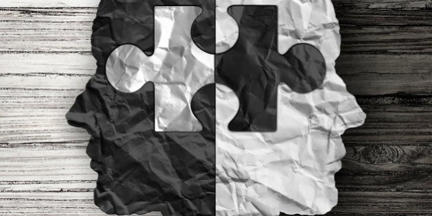 Racial ethnic social issue and equality concept or cultural justice symbol as a black and white crumpled paper shaped as a human head on old rustic wood background with a puzzle piece as a metaphor for social race issues.