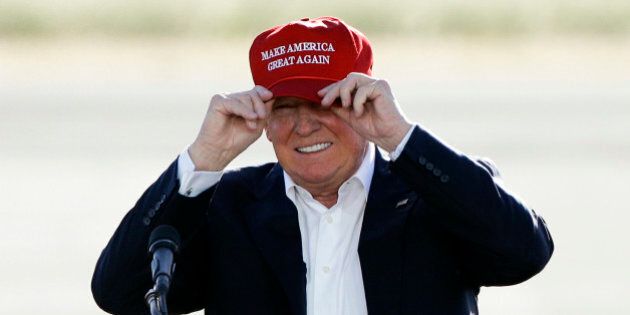 In this June 1, 2016, photo, Republican presidential candidate Donald Trump wears his hat during a rally at the Sacramento International Jet Center in Sacramento, Calif. Trump is suggesting that the Obama administration, for political reasons, plans to keep consumers in the dark about premium increases for 2017 under the president's health care law. But the administration says next year's sign-up season is going ahead on schedule; insurers say they've seen no indication of a delay. (AP Photo/Jae C. Hong)