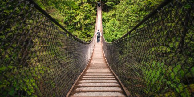 A tourist walks across the Lynn Canyon Suspension Bridge near Vancouver, Canada.