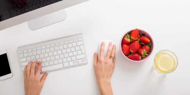 Strawberries and lemon water on office table