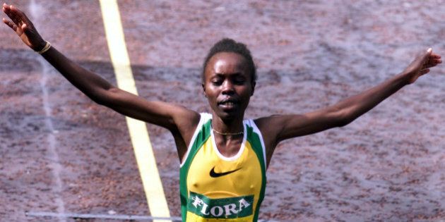 Kenya's Tegla Loroupe raises her arms in celebration as she crosses the finish line to win the women's London marathon April 16. Loroupe won her first London title in an unofficial two hours 24 minutes 33 seconds.IW