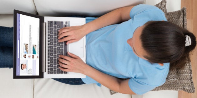 High Angle View Of Woman Chatting On Social Networking Site On Laptop
