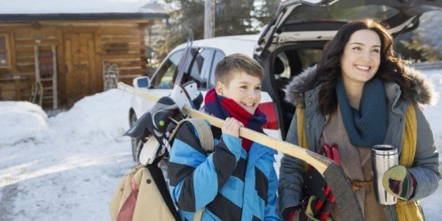 Mother and son standing outdoors with winter sports gear