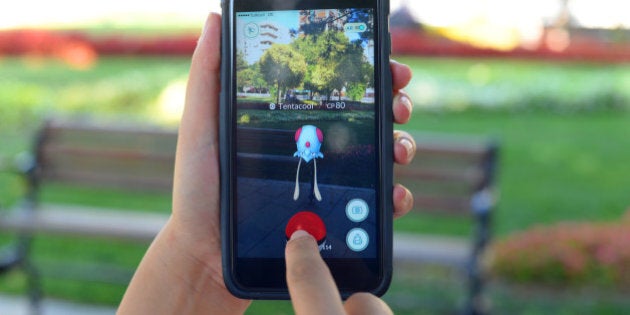İstanbul, Turkey - July 22, 2016: Woman hands holding and touching an Apple iPhone 6 Plus displaying Pokemon Go application in a park. iPhone 6 plus is a smart phone produced by Apple Computer, Inc