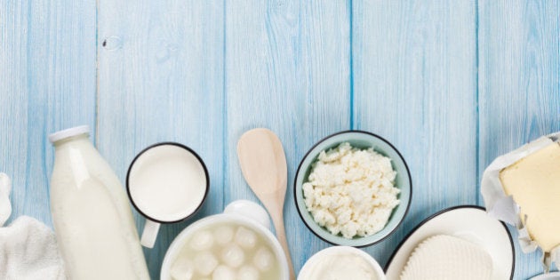 Dairy products on wooden table. Sour cream, milk, cheese, yogurt and butter. Top view with copy space