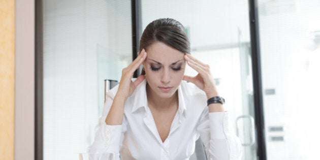 Overworking business woman suffering from headache