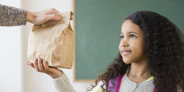 Student taking brown bag lunch in classroom