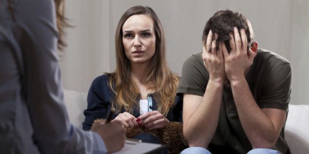 Young unhappy couple at odds on therapy visit