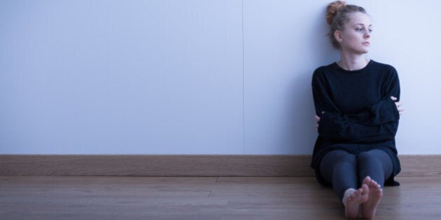 Lonely thoughtful girl sitting on the floor