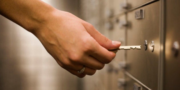 Woman's hand holding key to safety deposit box