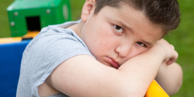 tired sad fat boy sitting on a fitness equipment