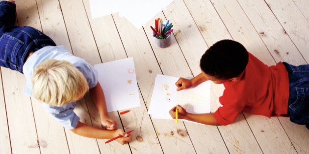 high angle view of two boys (8-10) lying on the floor, drawing