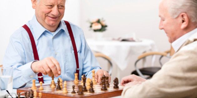 Nursing home: Senior men playing chess, focus on face