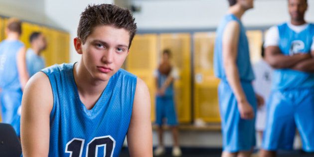 Disappointed teen in high school locker room after game