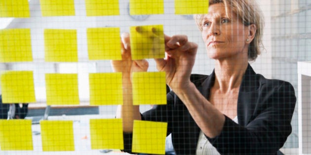 Businesswoman posting post-it