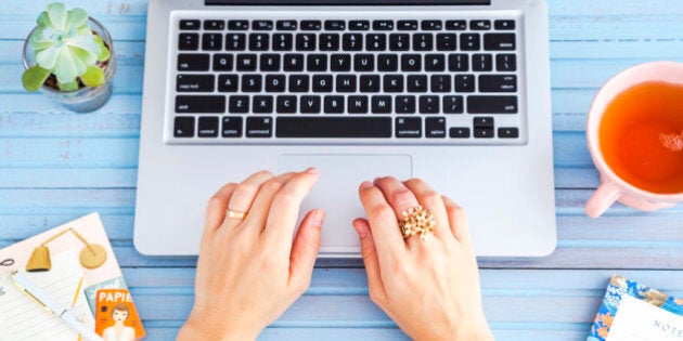 Woman's hands working at the notebook.