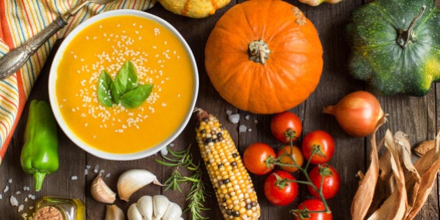 Fresh pumpkin soup and vegetables on a wooden table