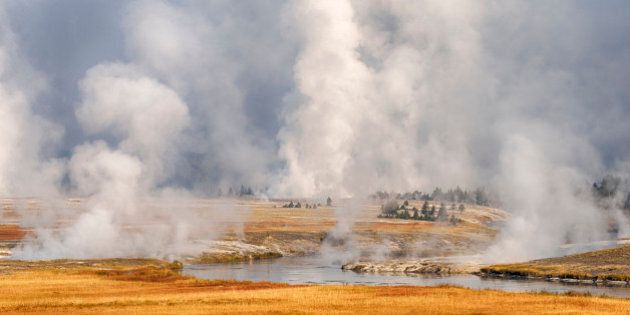Steam rises from Grand Prismatic Spring and near river path from Firehole River, autumn. UNESCO World Heritage Site. Firehole River, Grand Prismatic Spring, Midway Geyser Basin, Yellowstone National Park, Wyoming, USA, North America.