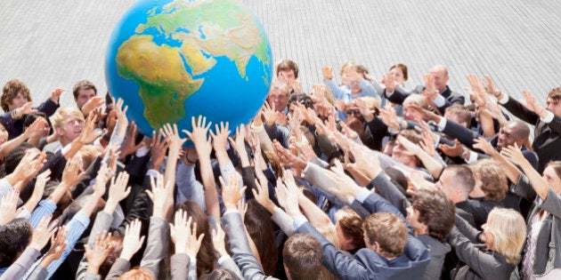 Crowd of business people reaching for globe