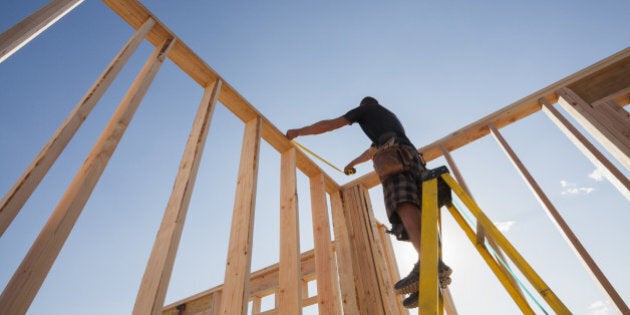 Caucasian man measuring frame on construction site