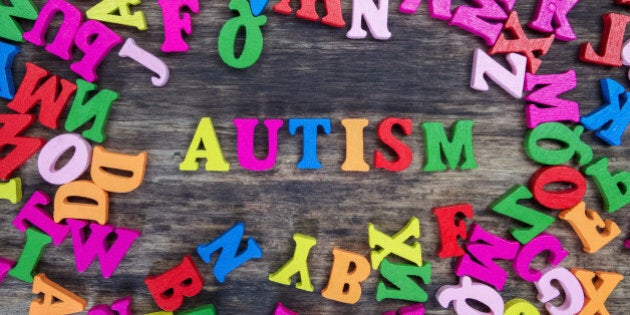 Colourful letters spelling out Autism on a wooden background