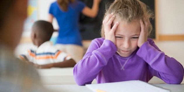 Schoolgirl (8-9) having problems while learning in classroom