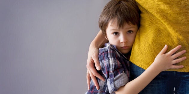 Sad little child, boy, hugging his mother at home, isolated image, copy space. Family concept