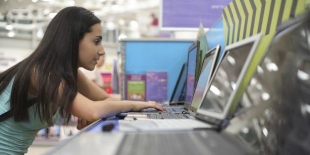 Teenage girl 916-17) using laptop in computer store